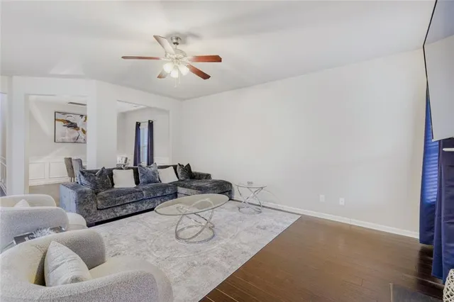 a living room with furniture and a ceiling fan