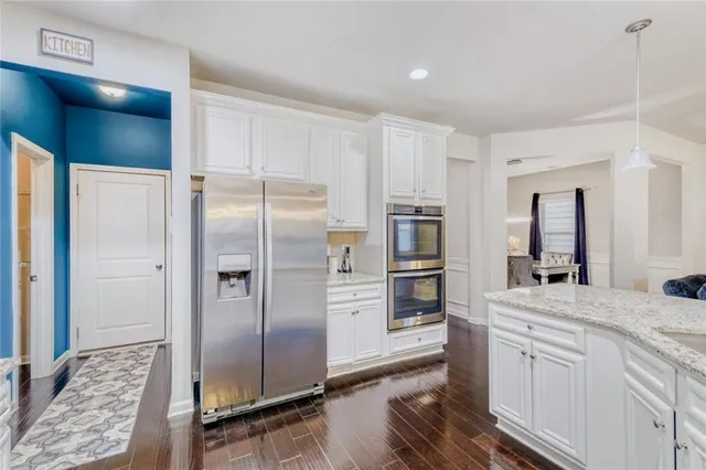a kitchen with kitchen island a counter top space cabinets and stainless steel appliances