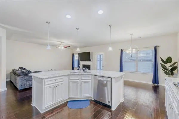 a large white kitchen with a sink and cabinets