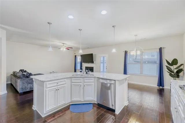 a large white kitchen with a sink and cabinets