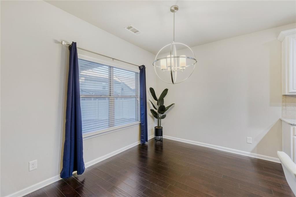 7607 Crawford Court Fairburn, GA 30213 - Photo 10 of 32 an empty room with wooden floor mirror and windows