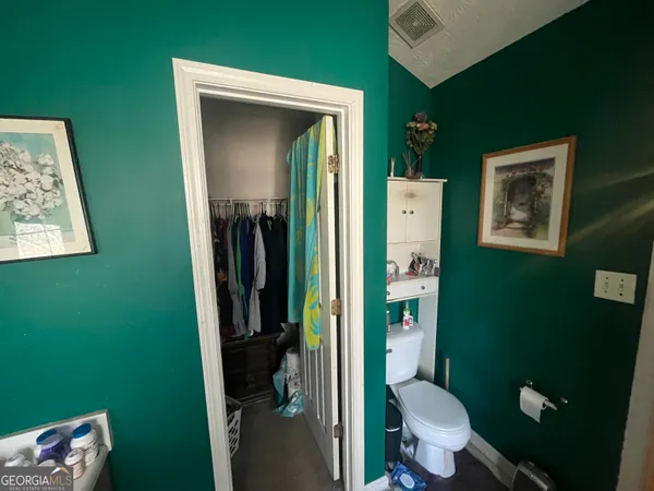 a bathroom with a toilet and a shower curtain