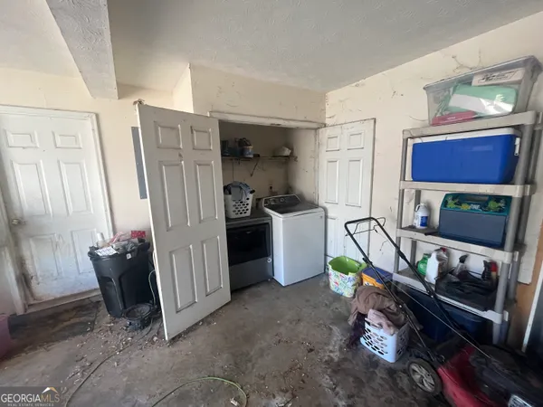 a living room with furniture a flat screen tv and a refrigerator