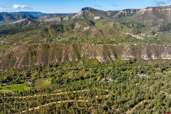 a view of a houses with a lush green hillside
