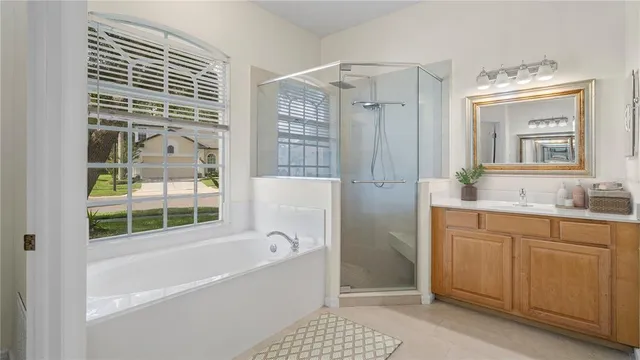 a bathroom with a granite countertop sink a mirror and a bathtub