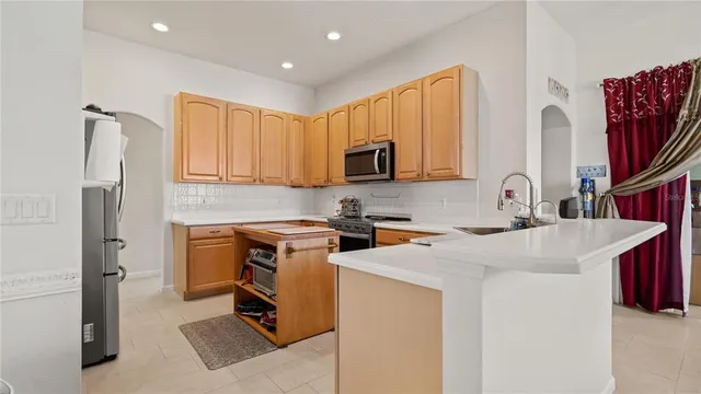 a kitchen with stainless steel appliances granite countertop a sink stove refrigerator and cabinets