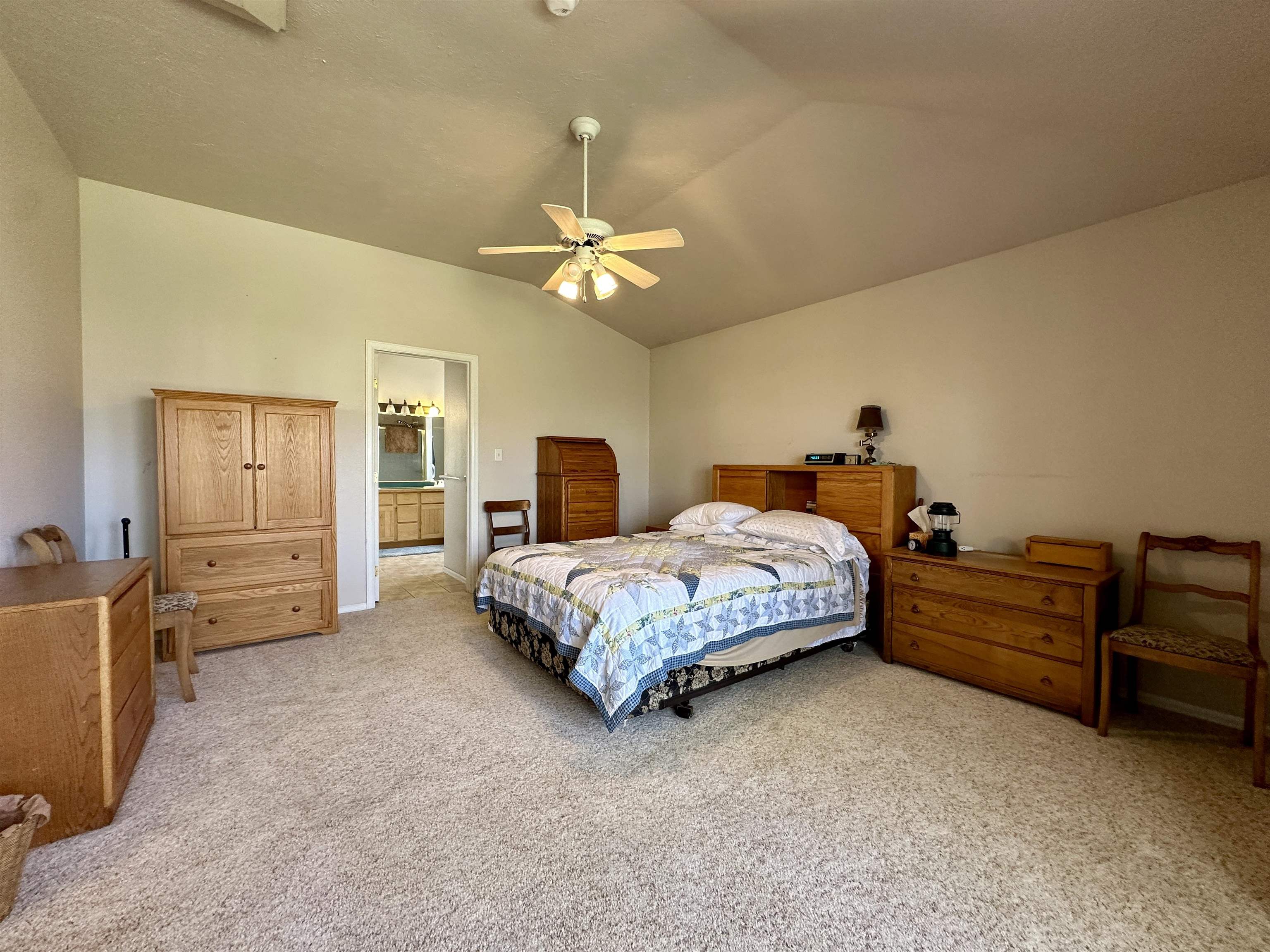 881 22 Road Grand Junction, CO 81505 - Photo 10 of 36 a spacious bedroom with a bed and a chandelier