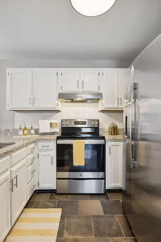 a bathroom with a granite countertop sink a mirror and a shower