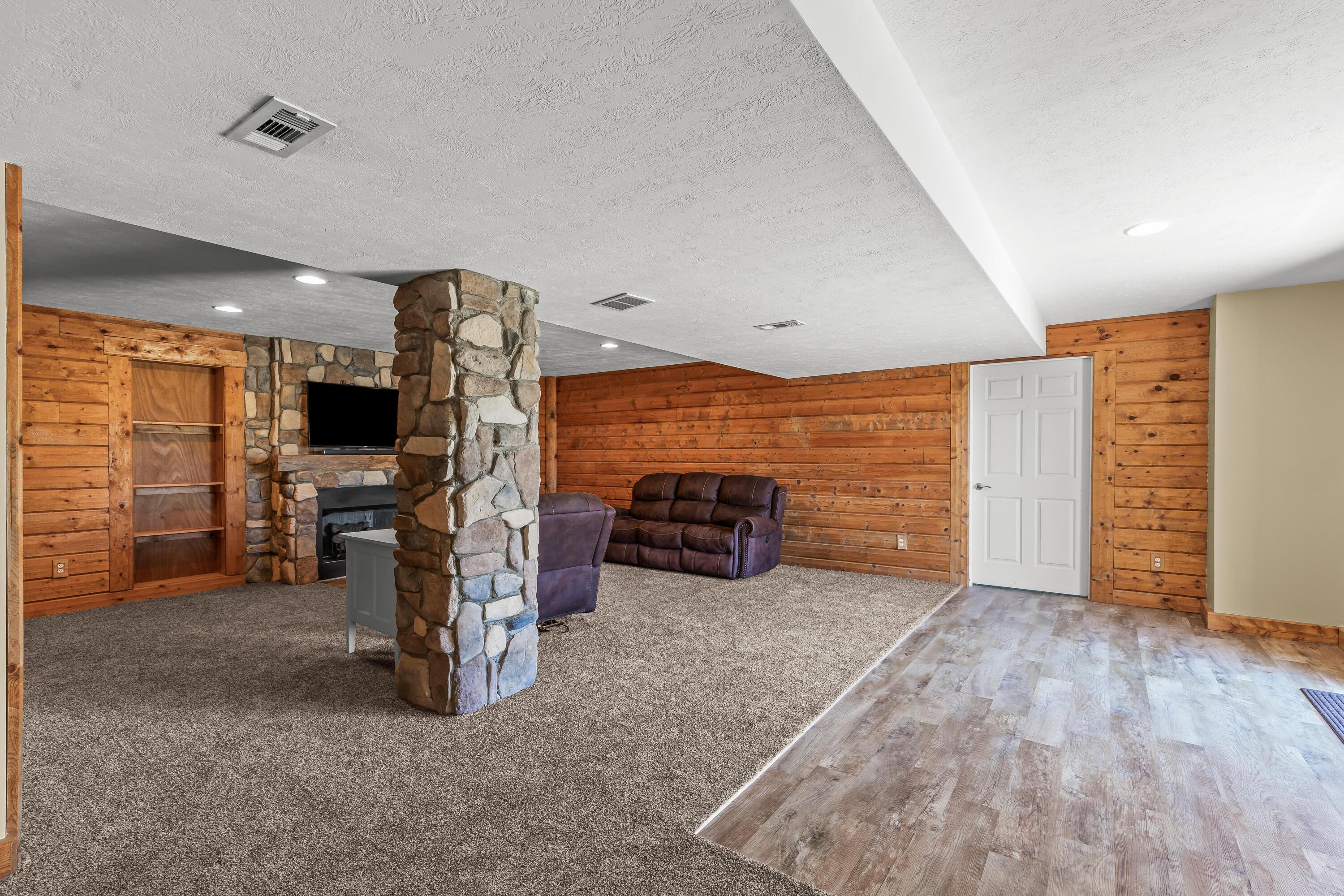 3582 Panhandle Road Delaware, OH 43015 - Photo 38 of 65 • New light sand carpet ~ 2024 • Ivory painted & wood planked walls • Gas fireplace with mantle • Built-in bookcases • Hidden door to private room • Luxury vinyl plank flooring at door landing • Double sliding doors to patio