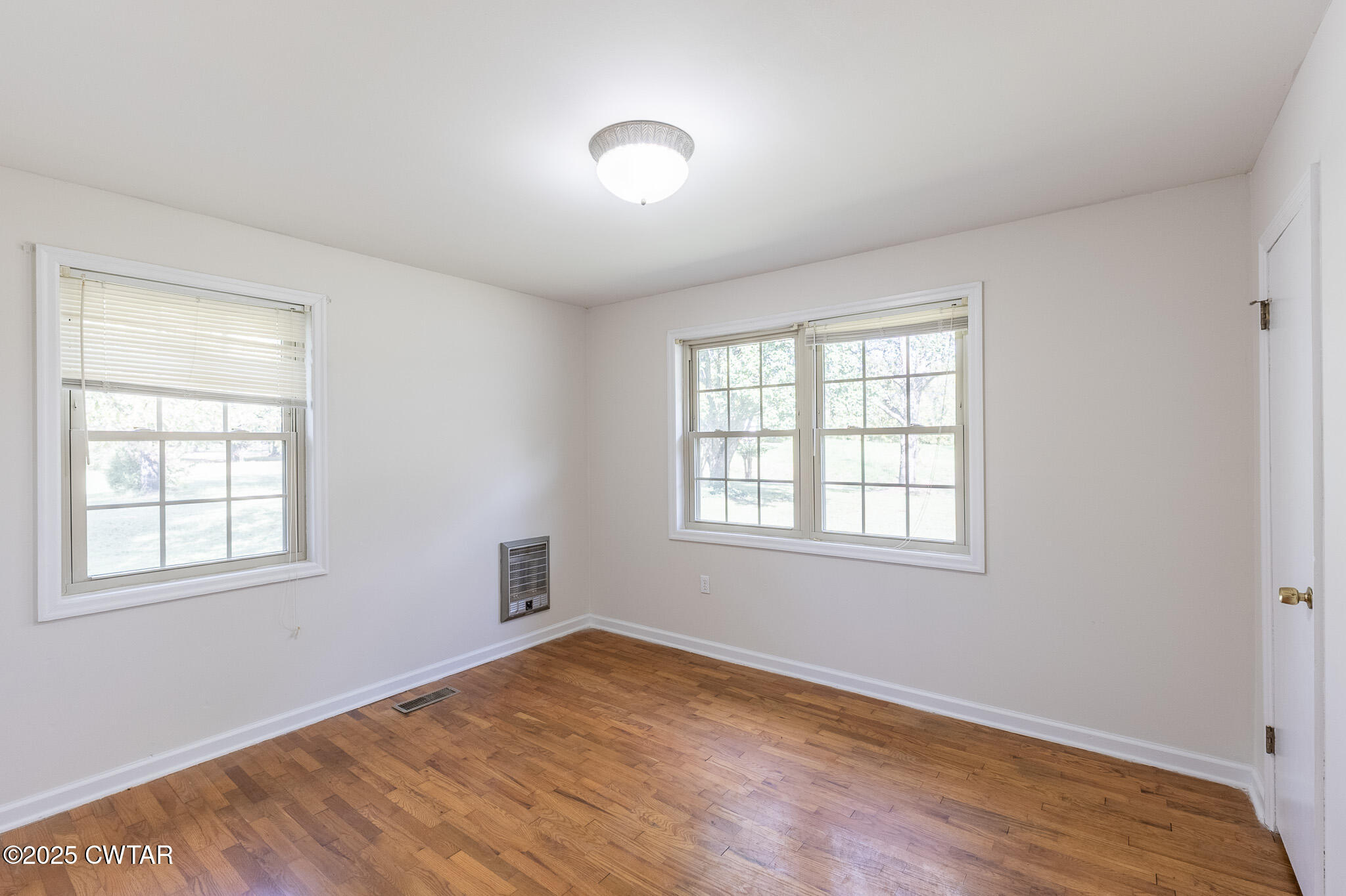 3330 Crucifer Road Huron, TN 38345 - Photo 9 of 15 an empty room with wooden floor and windows