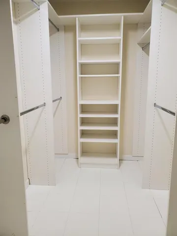 a view of walk in closet with empty racks