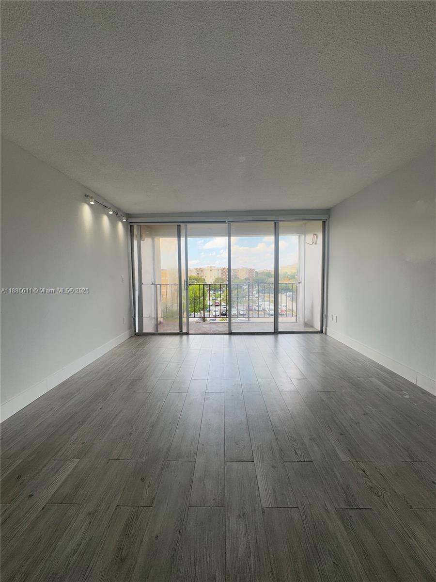 9220 Fontainebleau Boulevard, Unit 507 Miami, FL 33172 - Photo 4 of 9 wooden floor in an empty room with a window