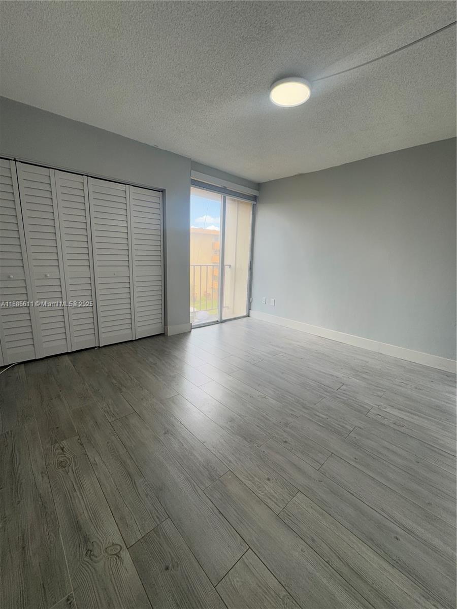 9220 Fontainebleau Boulevard, Unit 507 Miami, FL 33172 - Photo 5 of 9 a view of an empty room with wooden floor