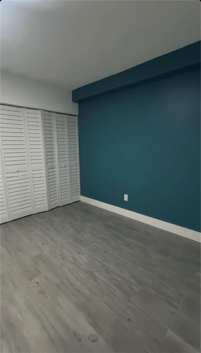 9220 Fontainebleau Boulevard, Unit 507 Miami, FL 33172 - Photo 6 of 9 an empty room with wooden floor