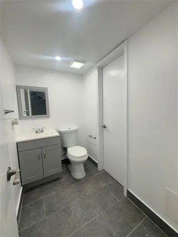 a spacious bathroom with a toilet sink and mirror