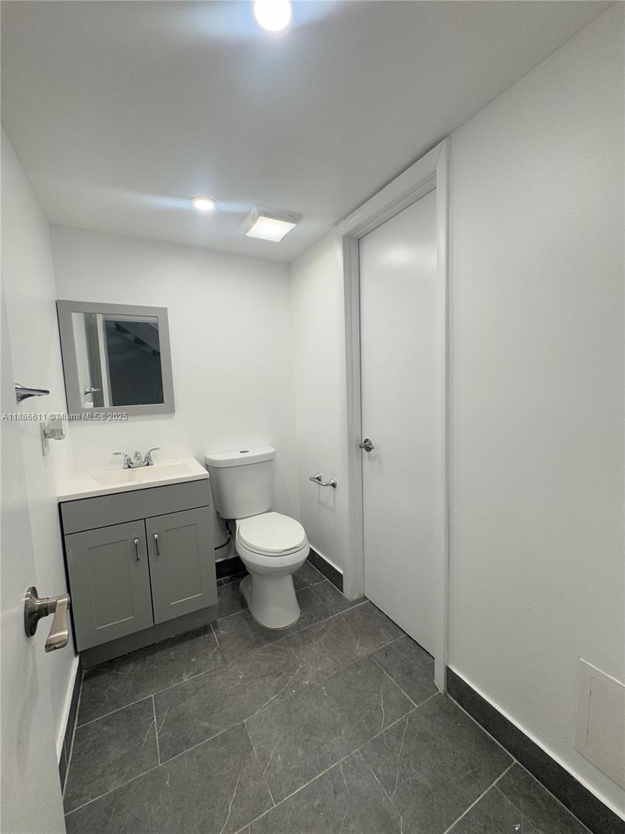 9220 Fontainebleau Boulevard, Unit 507 Miami, FL 33172 - Photo 7 of 9 a spacious bathroom with a toilet sink and mirror