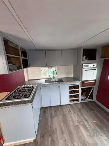 a kitchen with granite countertop a stove and cabinets