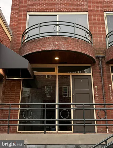 a view of an empty room with wooden floor and windows