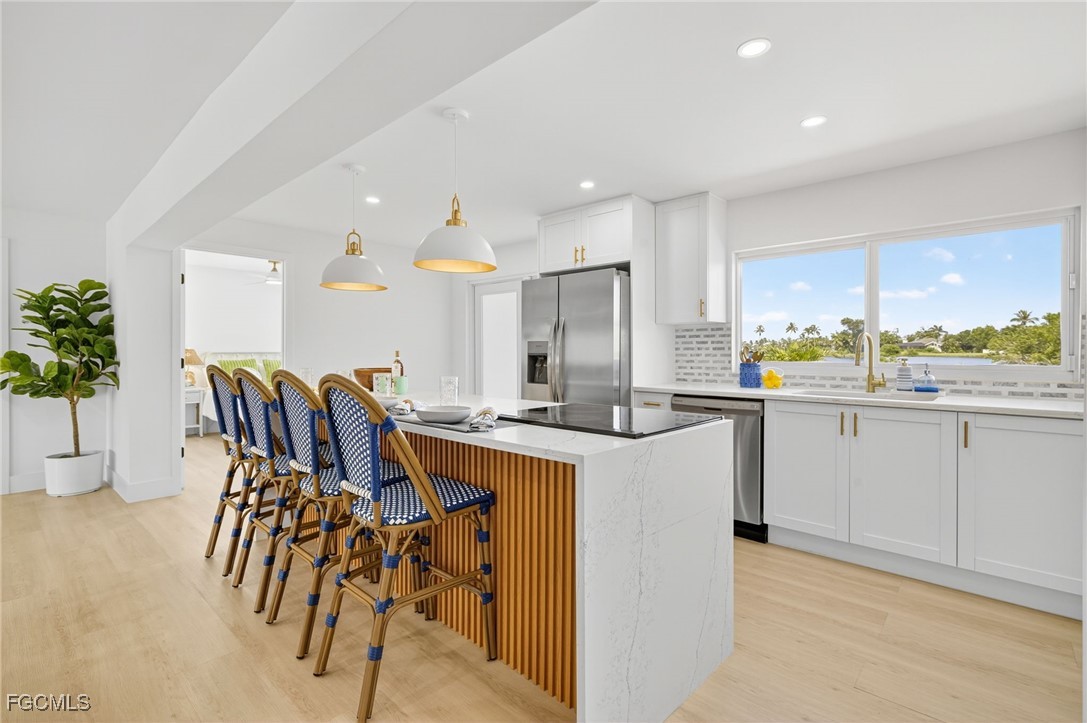1377 Sand Castle Road Sanibel, FL 33957 - Photo 11 of 49 a kitchen with a table chairs sink and cabinets