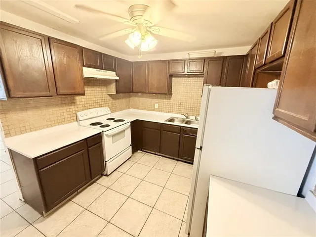 a kitchen with stainless steel appliances a sink a stove a refrigerator and cabinets