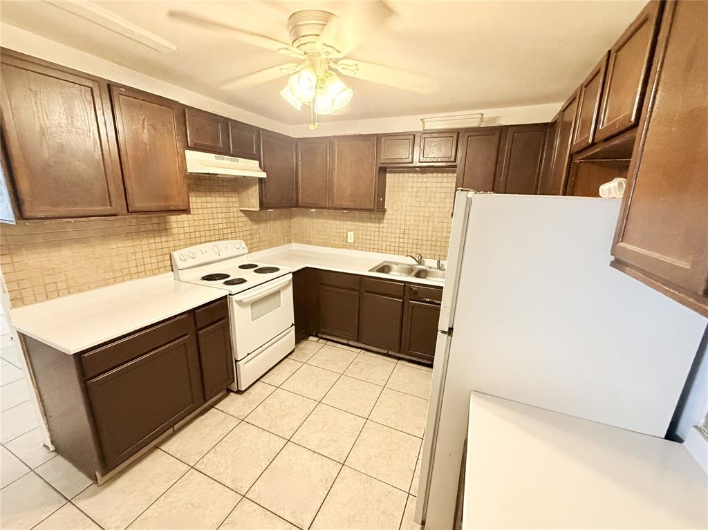 1829 North A Street, Unit 13 Lake Worth Beach, FL 33460 - Photo 2 of 14 a kitchen with stainless steel appliances a sink a stove a refrigerator and cabinets