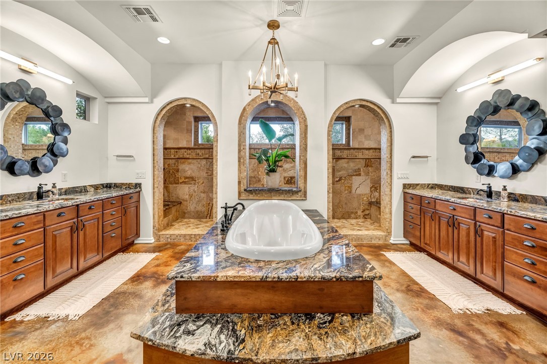 1158 Christian Road Henderson, NV 89002 - Photo 26 of 71 This spacious primary bathroom features a luxurious tub and walk-in showers.
