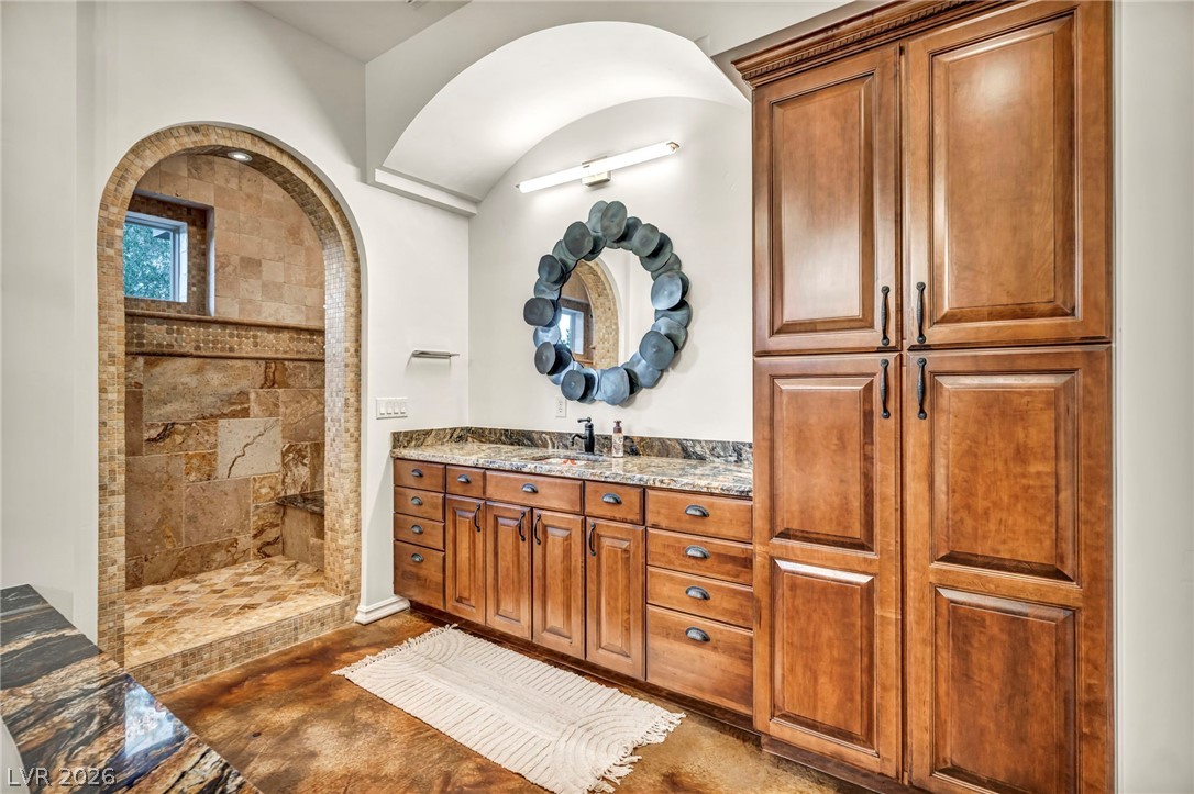 1158 Christian Road Henderson, NV 89002 - Photo 27 of 71 This bathroom features a spacious shower with stone tiling and a generous vanity with ample storage.
