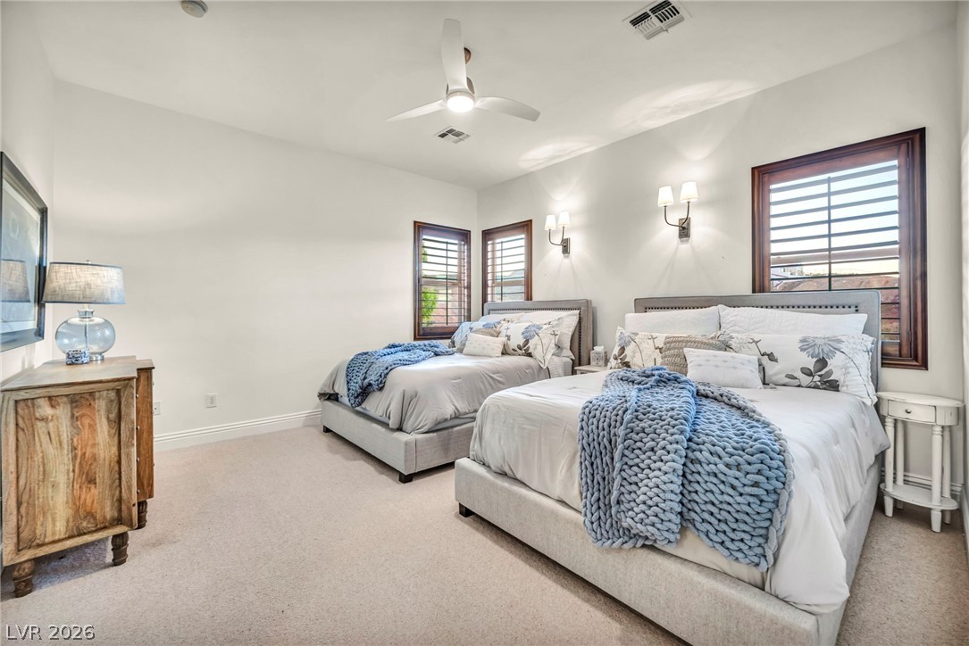 1158 Christian Road Henderson, NV 89002 - Photo 40 of 71 This bright bedroom features a ceiling fan, plush carpet, and natural light from shuttered windows.