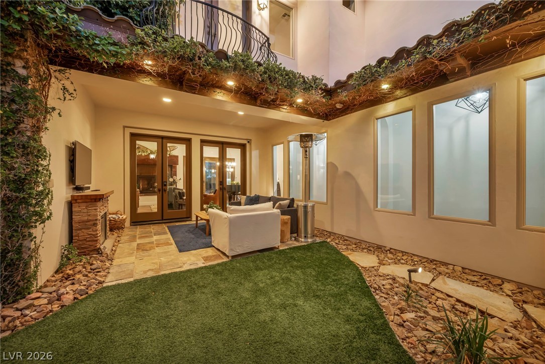 1158 Christian Road Henderson, NV 89002 - Photo 7 of 71 An inviting outdoor living area awaits, complete with a cozy fireplace and lush greenery.