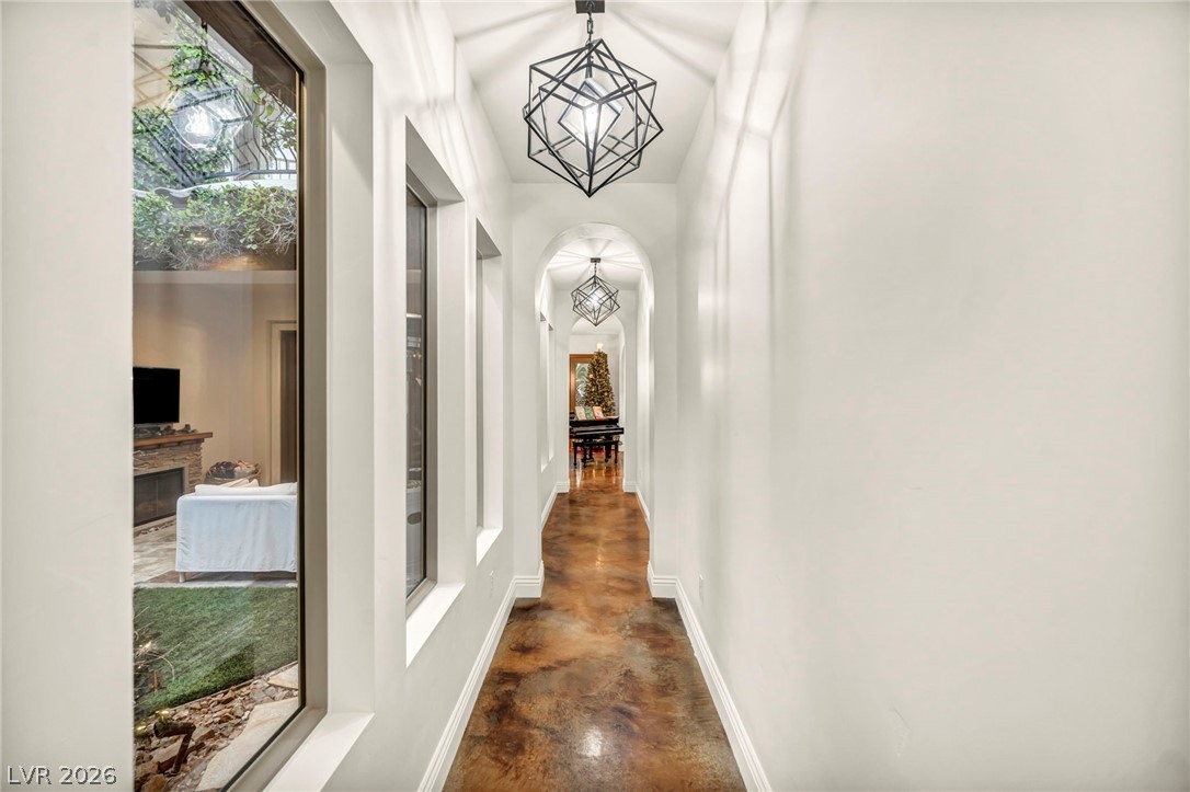 1158 Christian Road Henderson, NV 89002 - Photo 10 of 71 This interior hallway features striking geometric pendant lights and rich, textured flooring.