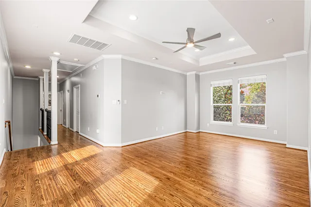 a view of a livingroom with wooden floor and a ceiling fan