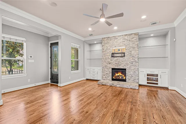 an empty room with windows a fireplace