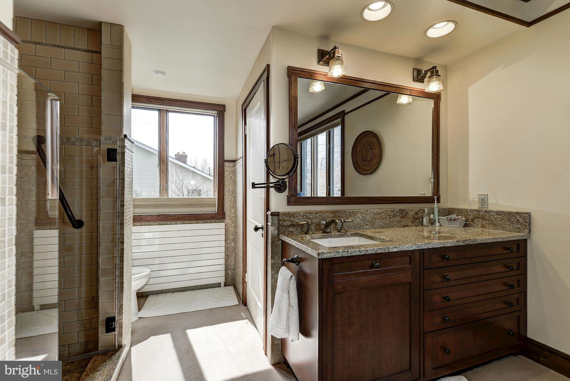 4000 Harrison Street Northwest Washington, DC 20015 - Photo 18 of 23 a bathroom with a granite countertop sink a mirror and a shower