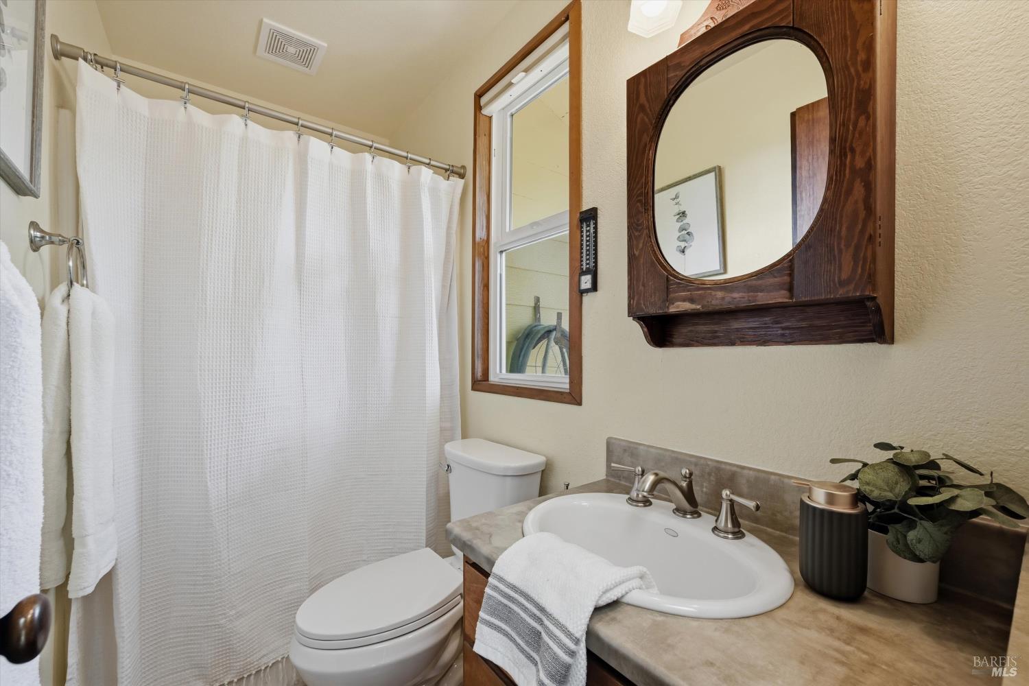 19897 Donkey Hill Road Hidden Valley Lake, CA 95467 - Photo 18 of 45 a bathroom with a granite countertop toilet a sink and a mirror