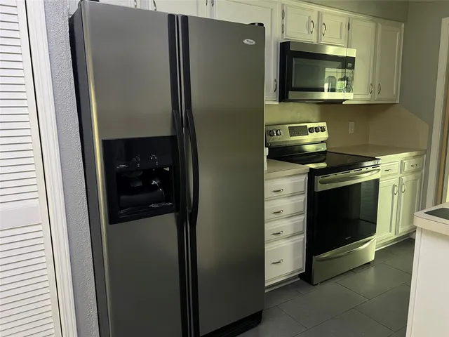 a kitchen with stainless steel appliances wooden cabinets and a refrigerator