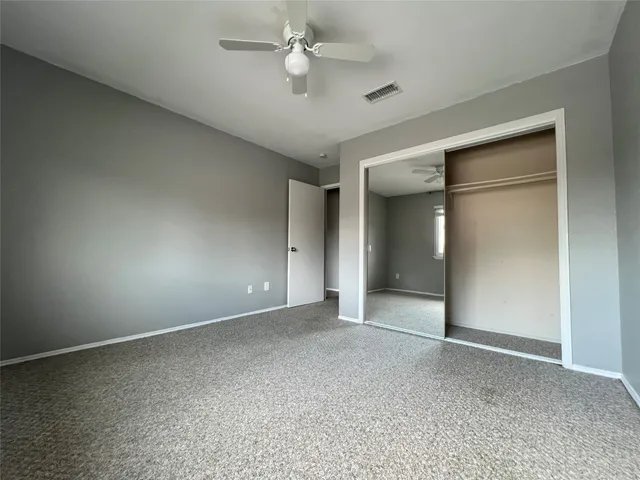a view of an empty room with a ceiling fan
