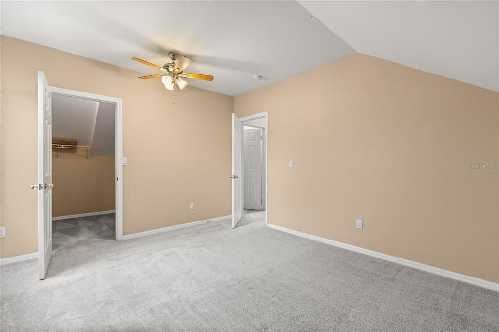 13607 Springtide Court Orlando, FL 32826 - Photo 13 of 32 an empty room with a chandelier fan and windows