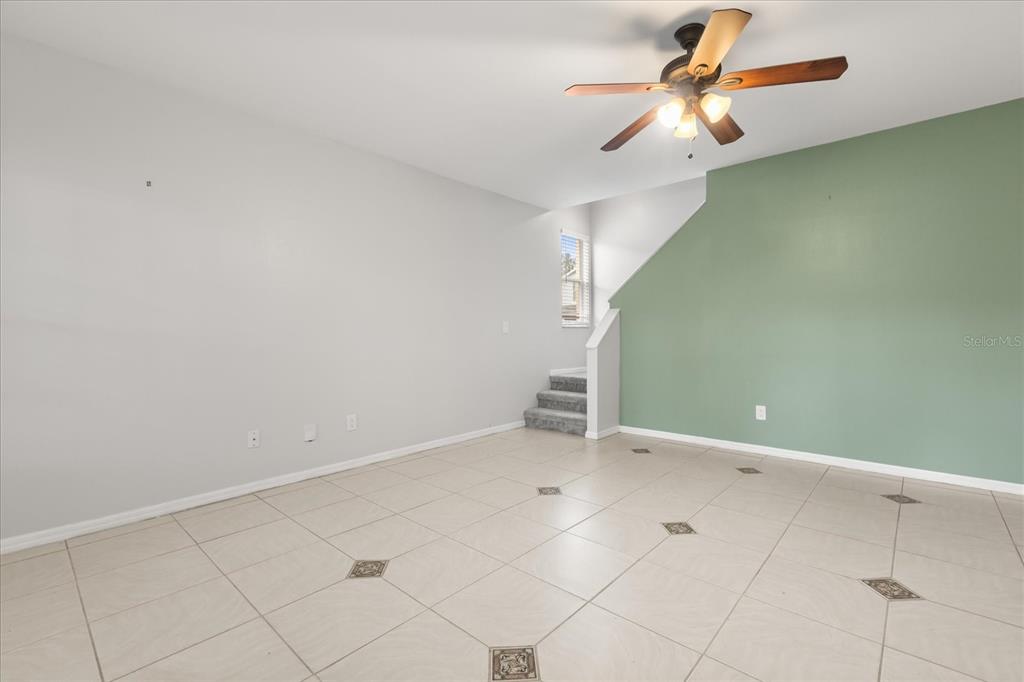 13607 Springtide Court Orlando, FL 32826 - Photo 7 of 32 an empty room with a ceiling fan and carpet