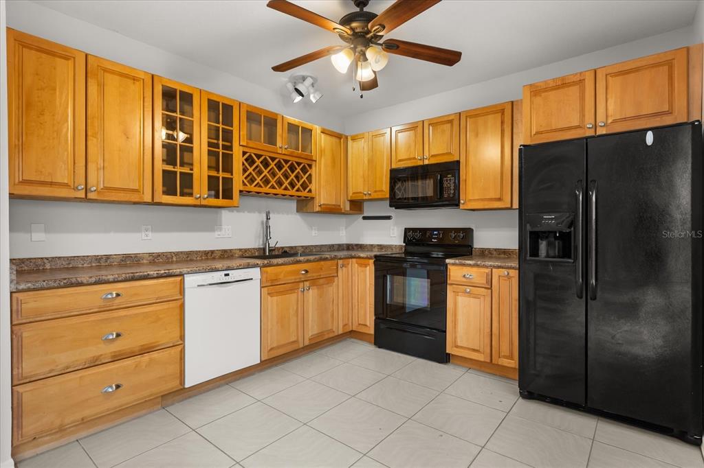 13607 Springtide Court Orlando, FL 32826 - Photo 9 of 32 a kitchen with stainless steel appliances granite countertop a refrigerator a stove top oven a sink and dishwasher