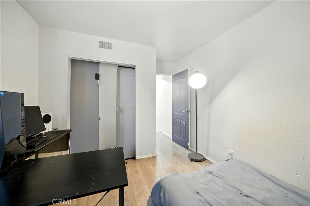 14937 Sherman Way, Unit 7 Van Nuys, CA 91405 - Photo 26 of 37 a bedroom with a bed and a computer on a table