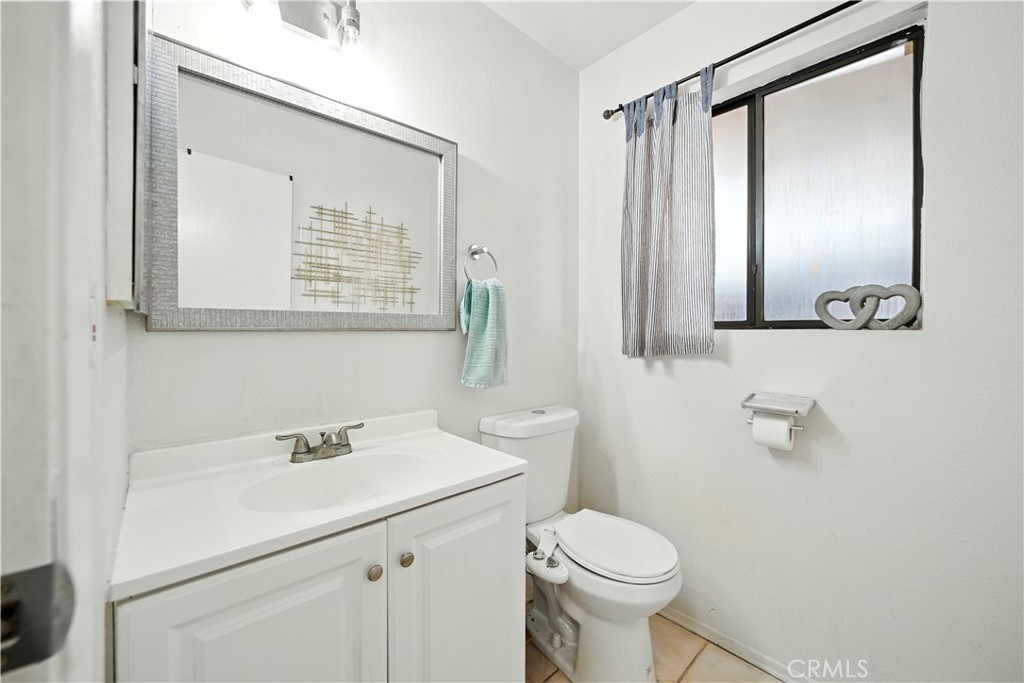 14937 Sherman Way, Unit 7 Van Nuys, CA 91405 - Photo 29 of 37 a bathroom with a sink toilet and mirror