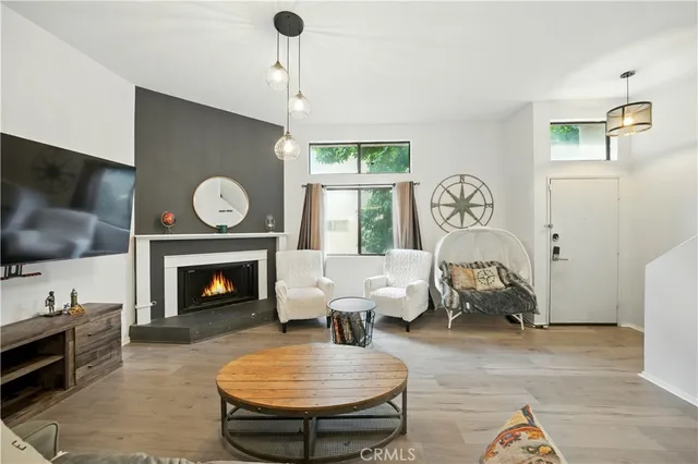 a living room with furniture a flat screen tv and a fireplace