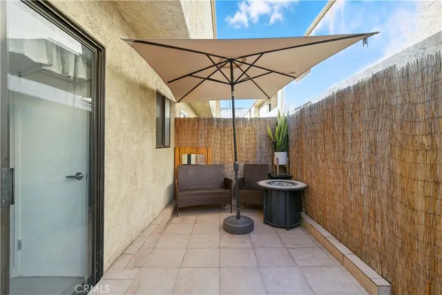 a view of a patio with a table and chairs and potted plants