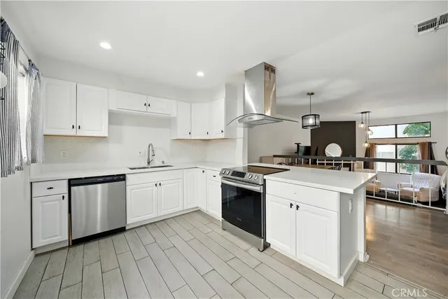 a kitchen with a stove cabinets and wooden floor