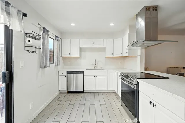 a kitchen with stainless steel appliances granite countertop a stove a sink and a refrigerator