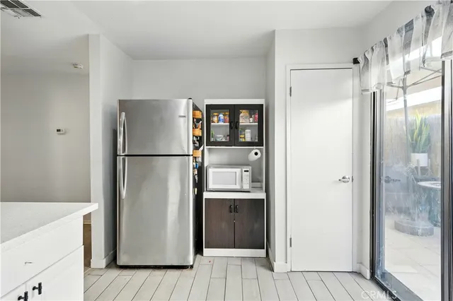 a kitchen with stainless steel appliances a refrigerator and a wooden floor