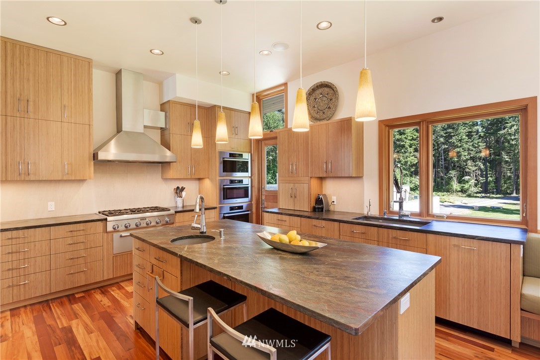 1224 Shark Reef Road Lopez Island, WA 98261 - Photo 11 of 34 a kitchen with stainless steel appliances granite countertop a stove a sink dishwasher and cabinets with wooden floor