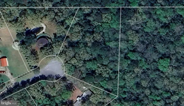 an aerial view of a house with a yard and large trees