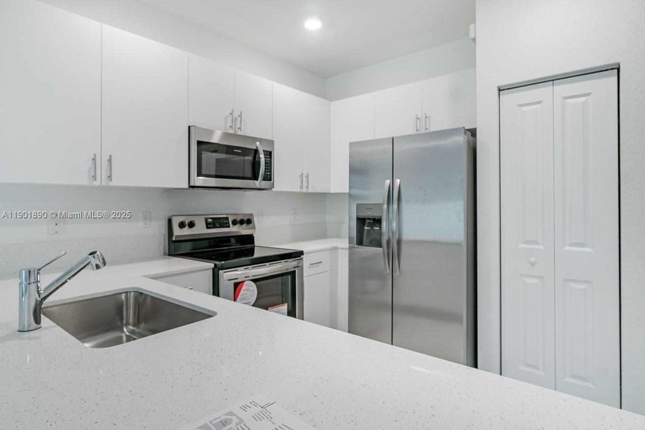 207 Southwest 159th Terrace Pembroke Pines, FL 33027 - Photo 12 of 37 a kitchen with a refrigerator sink and microwave