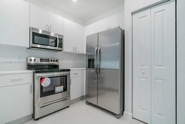 a kitchen with stainless steel appliances granite countertop a refrigerator and a stove top oven